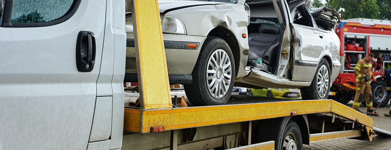 Wrecked car loading on tow truck after crash traffic accident, Concept of dangerous driving after drinking alcohol, Roadside assistance concept